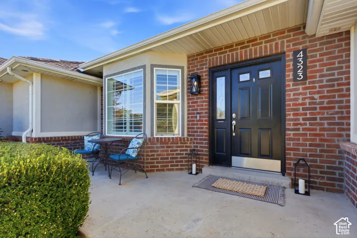 Brick exterior detailing a black entry door with transom windows