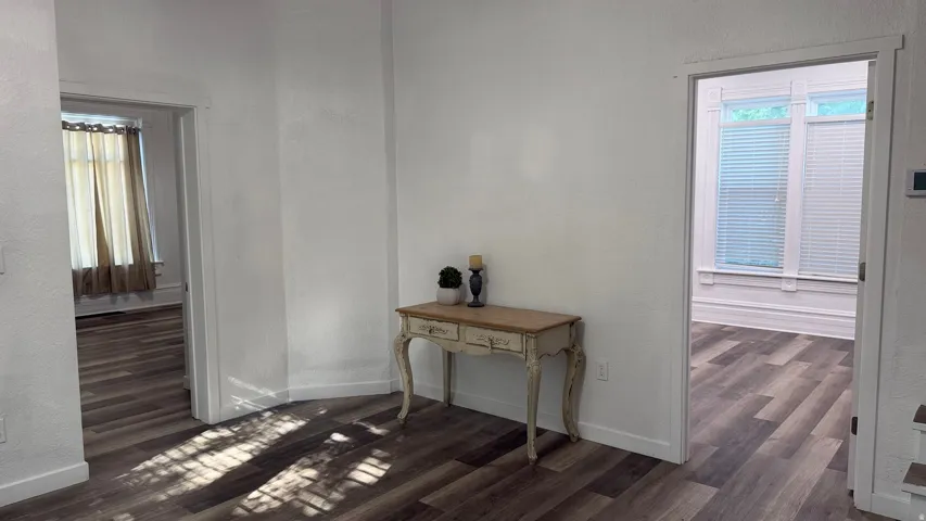 Wood-finish flooring throughout, white painted walls, and white trim