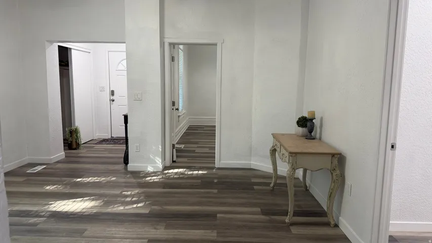 Wood-finish flooring throughout, white painted walls, and white trim