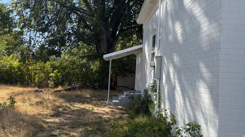 Painted brick exterior with covered entry and mature trees