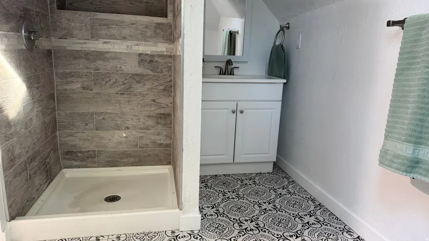 Shower with horizontal stone-look tile and mosaic accent