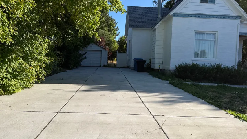 Expansive concrete driveway leading to a detached garage