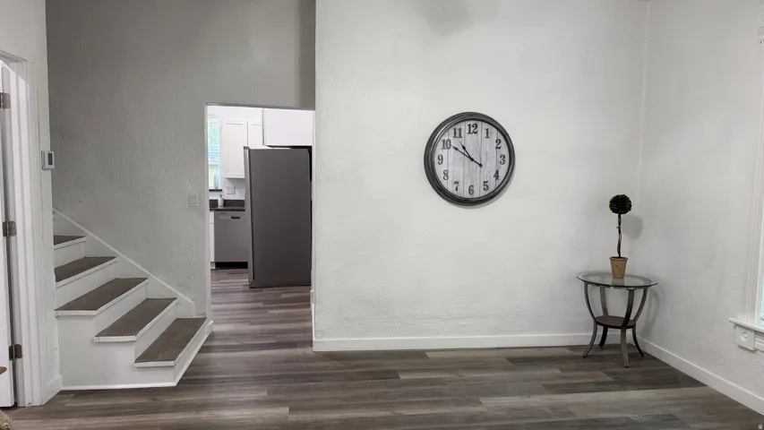 Wood-finish flooring, white painted walls, and white painted stair risers