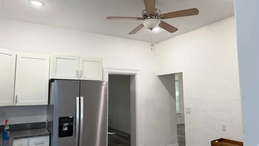 Kitchen area with recessed lighting, white cabinetry, a stainless steel refrigerator, and a ceiling fan with integrated lighting
