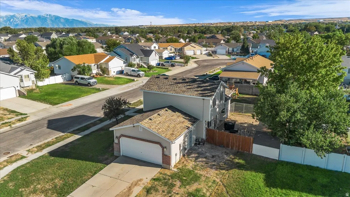 Two-story residence with an attached garage, featuring a shingle roof and a fenced rear yard