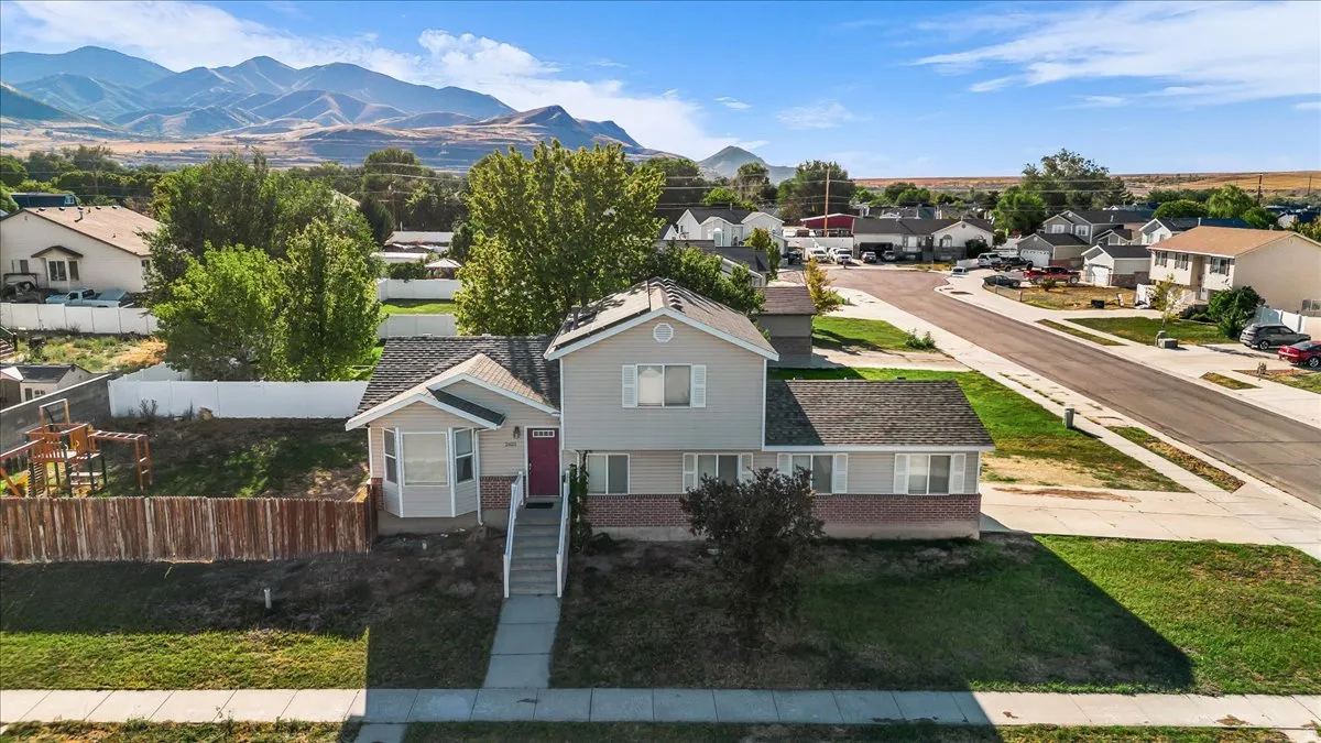 Two-story residence with a red entry door, established front yard, and a paved walkway