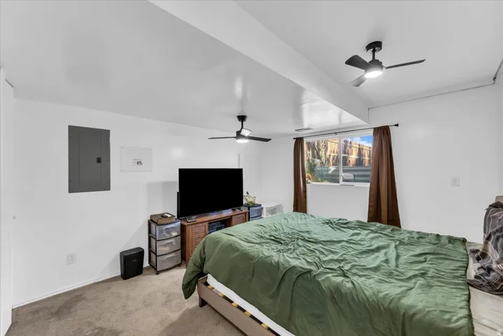 Recessed window, ceiling-mounted light fixtures, textured carpeting, and white painted walls