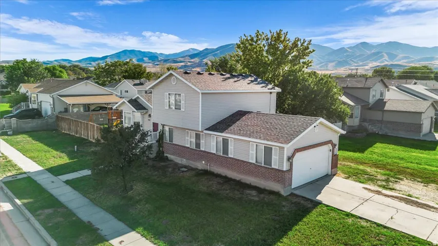 Two-story residence with a brick and siding exterior, attached garage, and a concrete driveway