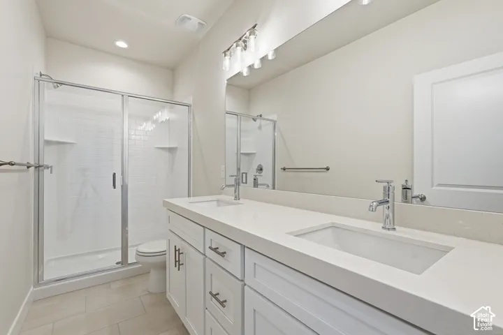 Dual vanity with undermount sinks, chrome fixtures, and white cabinetry