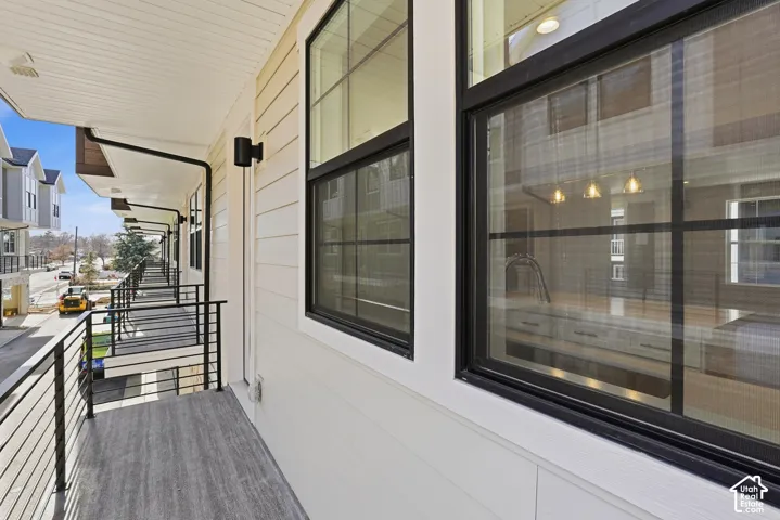 Exterior balcony with metal railings and wood-finish flooring