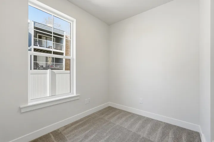 Neutral wall finishes with a single pane window featuring white trim