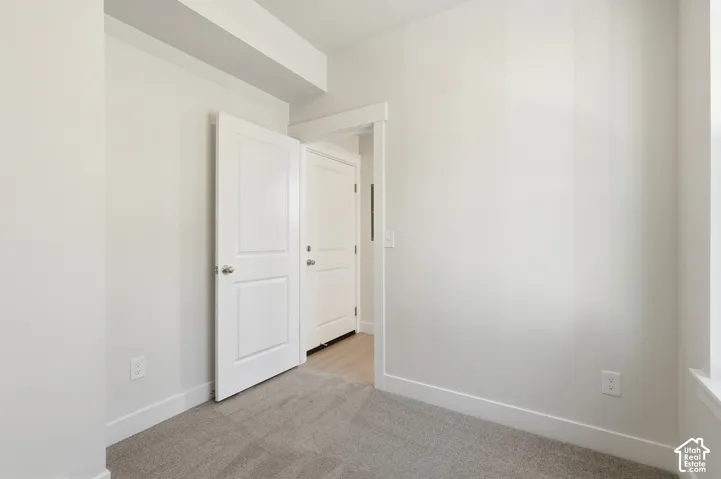 Neutral wall finishes, light gray carpeting, crisp white trim, and white interior doors