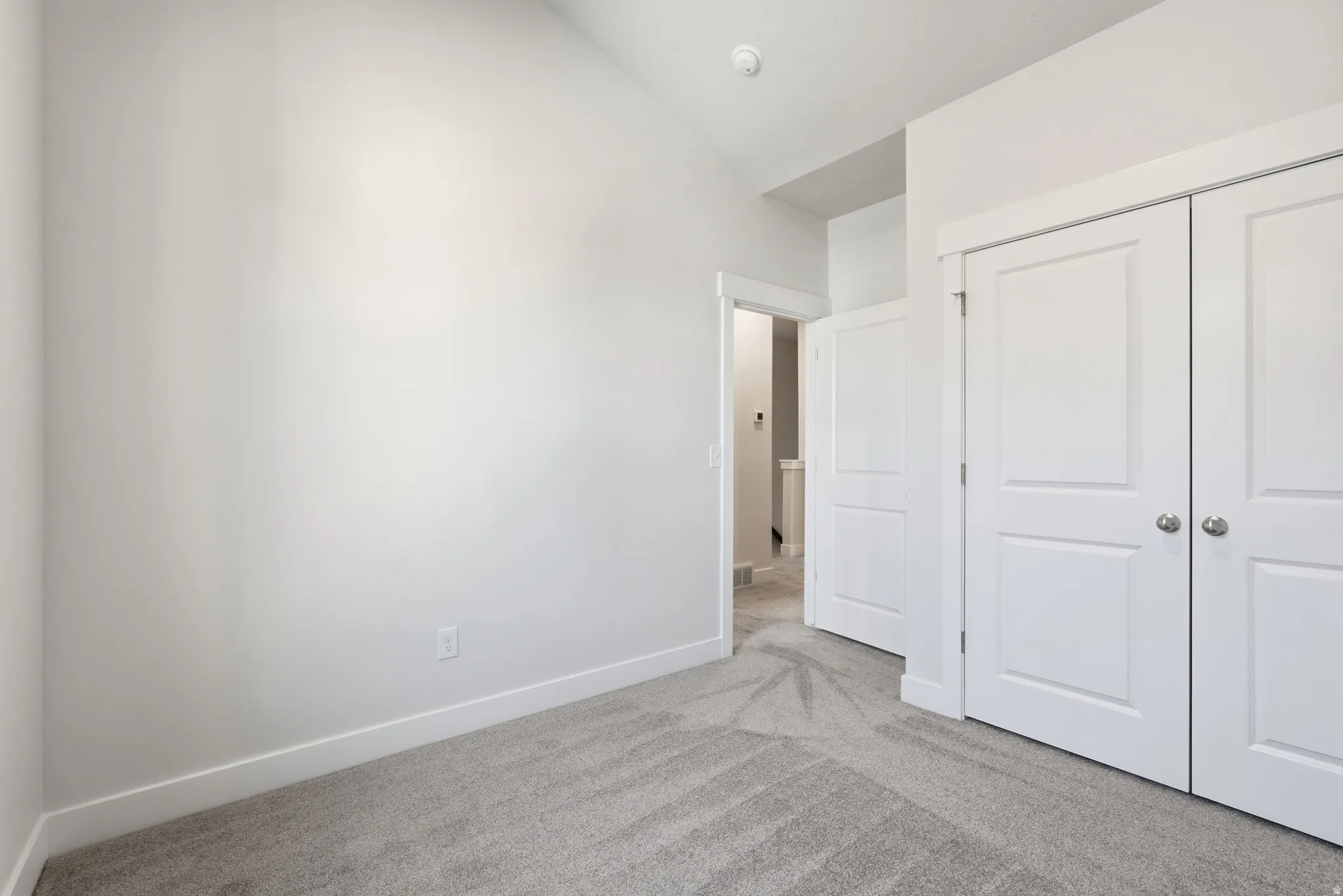 Neutral wall paint, light gray carpet, white trim, and white paneled doors