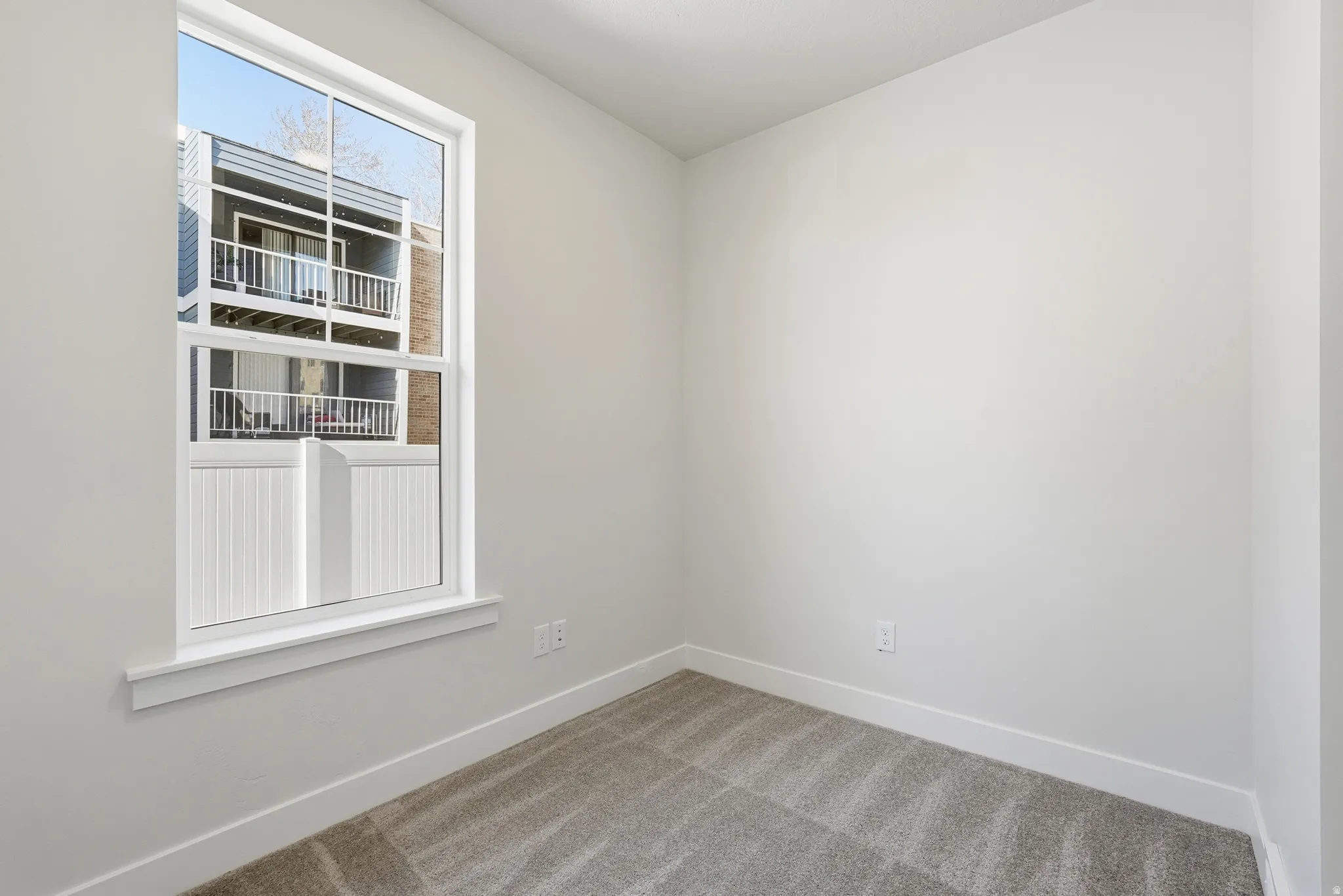 Neutral wall finishes with a single pane window featuring white trim