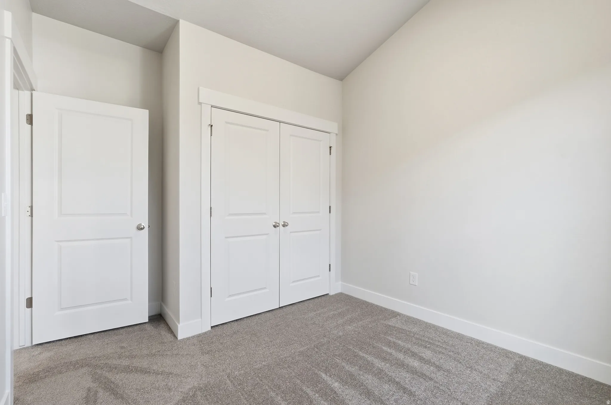 Plush gray carpeting, white trim, and white walls