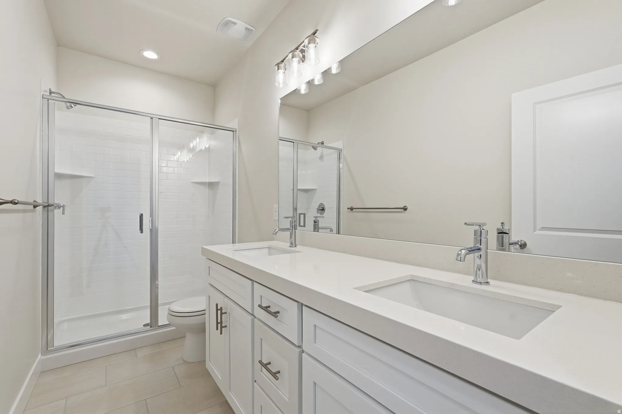 Dual vanity with undermount sinks, quartz countertops, and chrome fixtures
