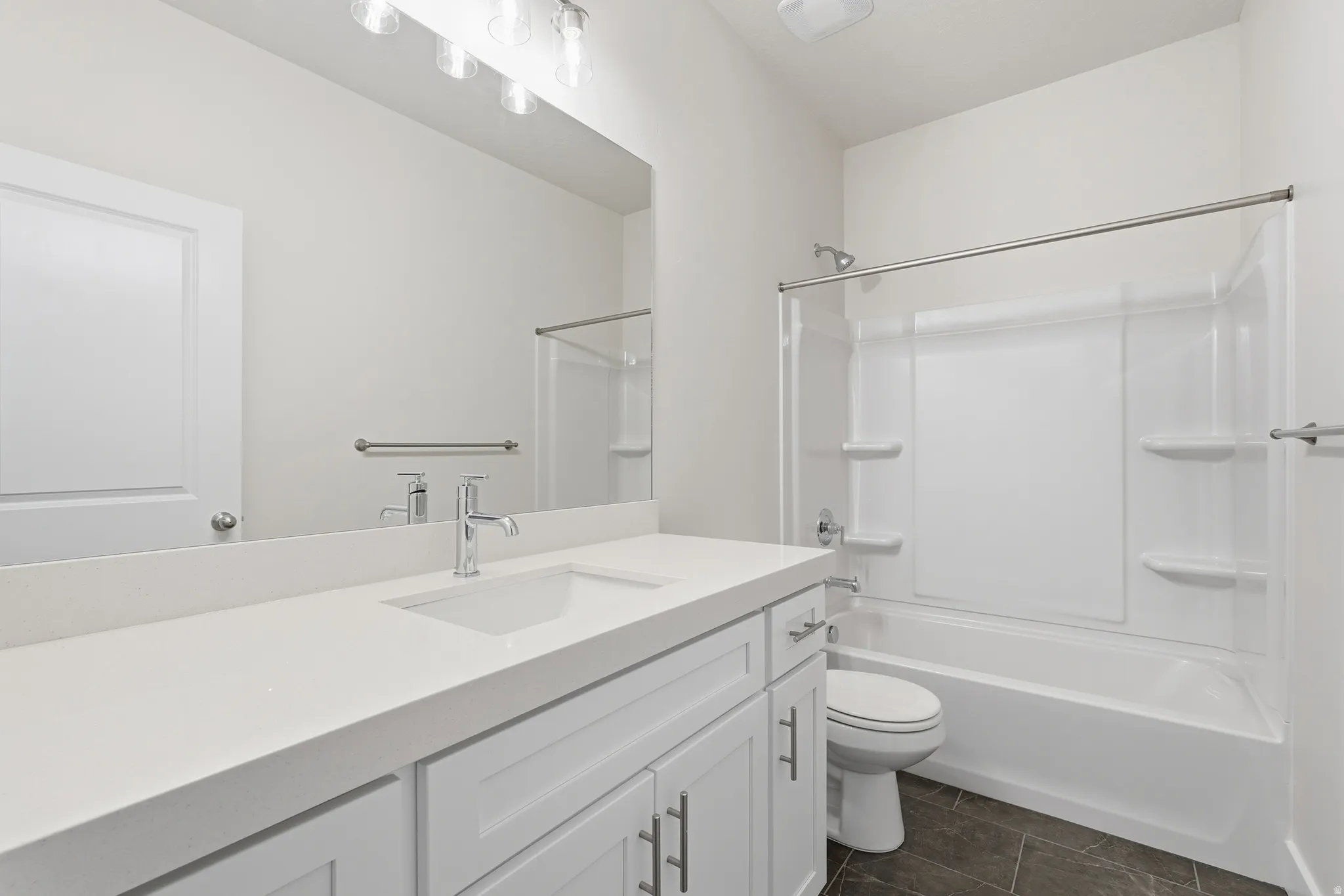 White vanity with an integrated sink, polished chrome faucet, and expansive mirror