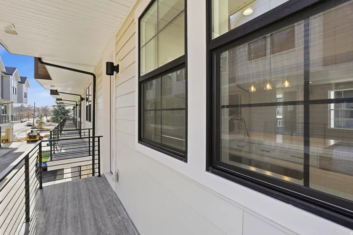 Balcony featuring wood-finish flooring and black metal railings