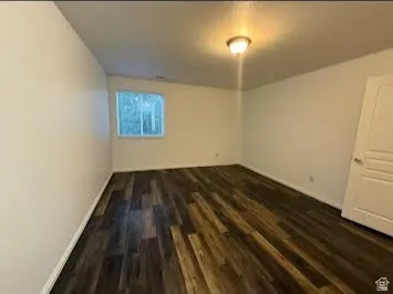 Wood-finish flooring, white walls, and a ceiling-mounted light fixture