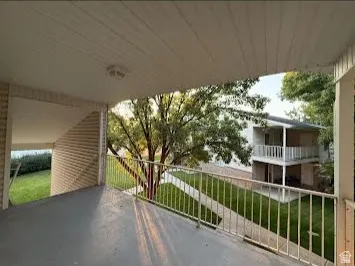 Covered outdoor balcony with a painted concrete floor and metal railing