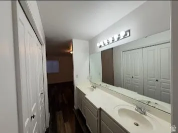 Dual vanity with integrated sinks, expansive mirror, and polished chrome light fixture