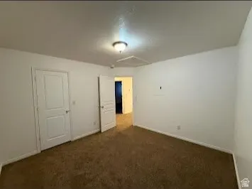 Neutral wall finishes, textured carpeting, and a flush-mount ceiling light fixture