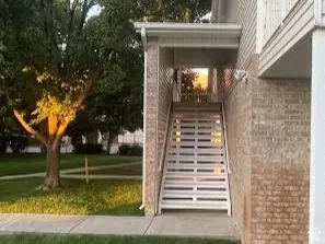 Brick exterior with siding accents and a white metal staircase