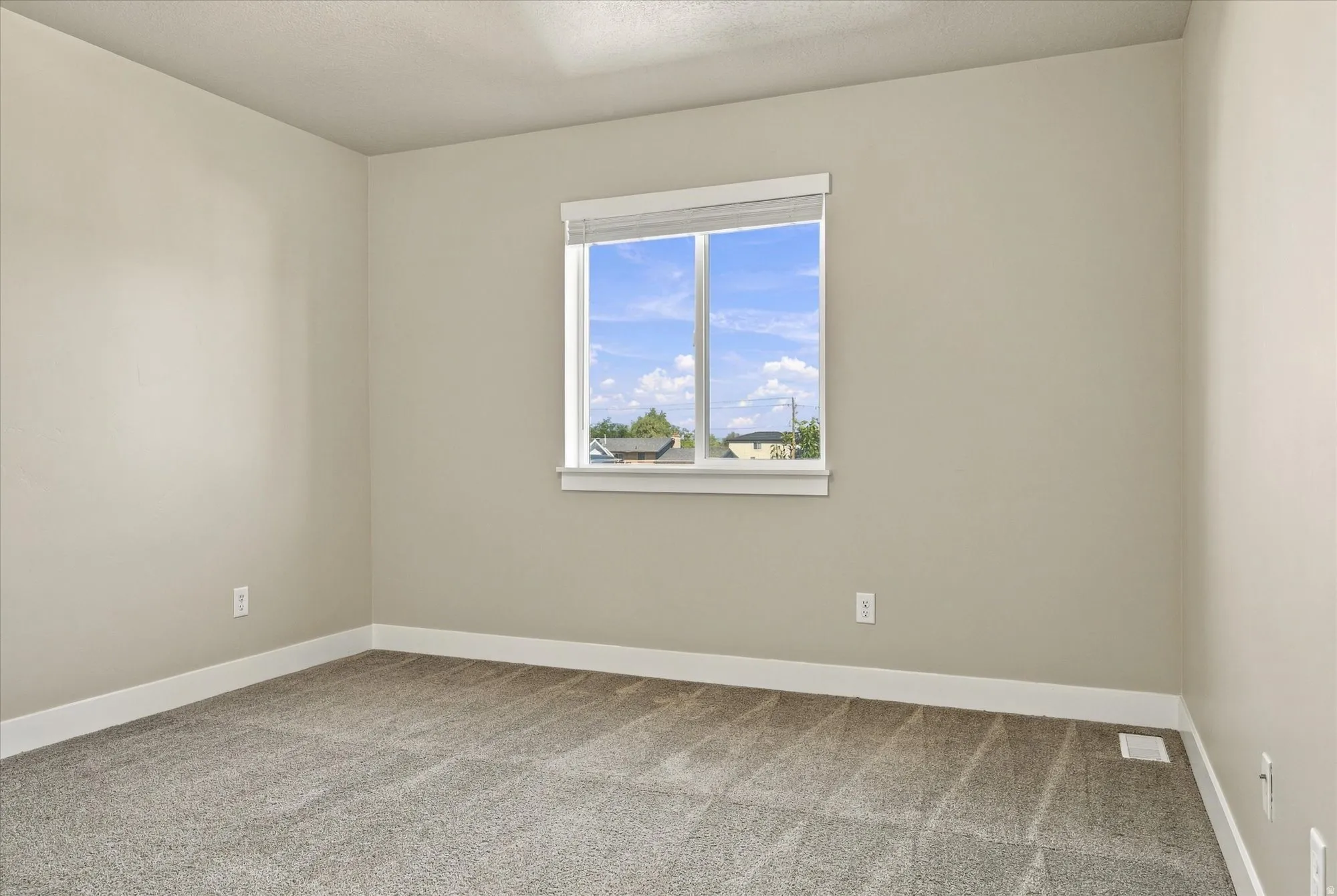 Neutral painted walls with a window featuring white trim