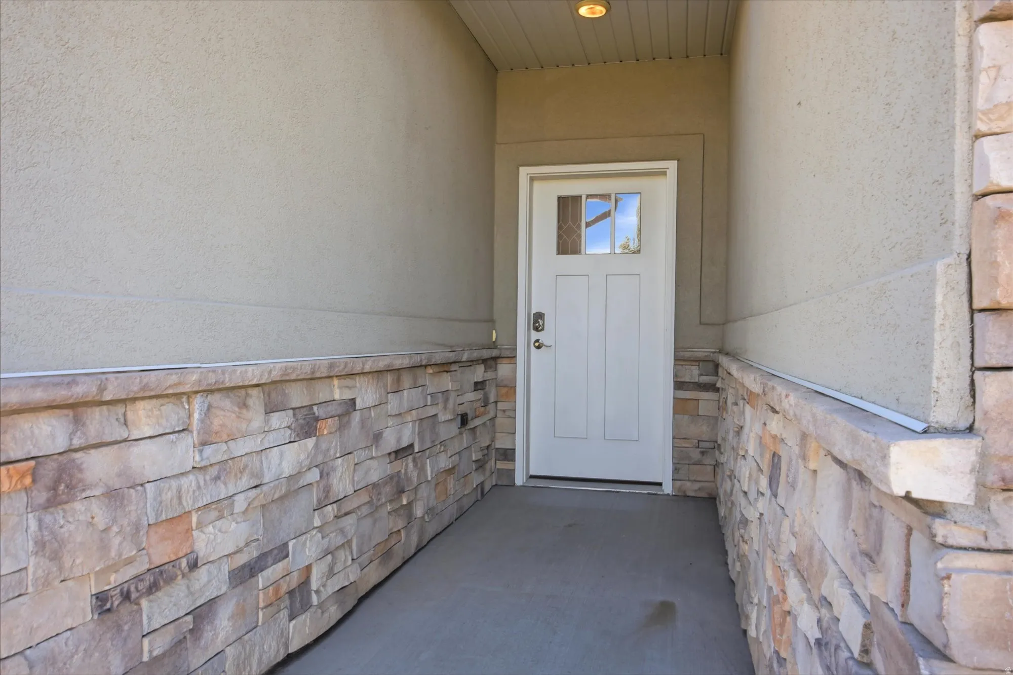 Covered entry with stone veneer and stucco finishes
