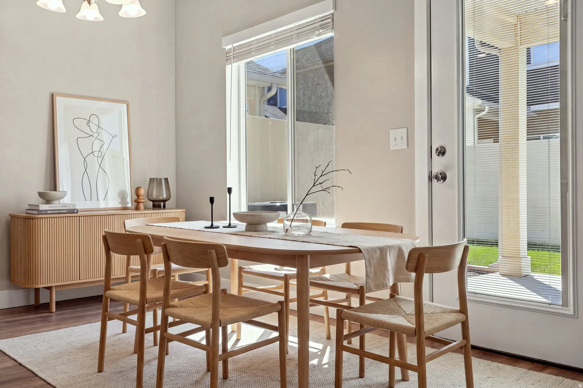 Hardwood-style flooring, light-colored walls, window with blinds, and glass-paneled door