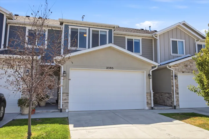 Contemporary exterior with a two-car garage, stone and stucco accents, and multiple windows