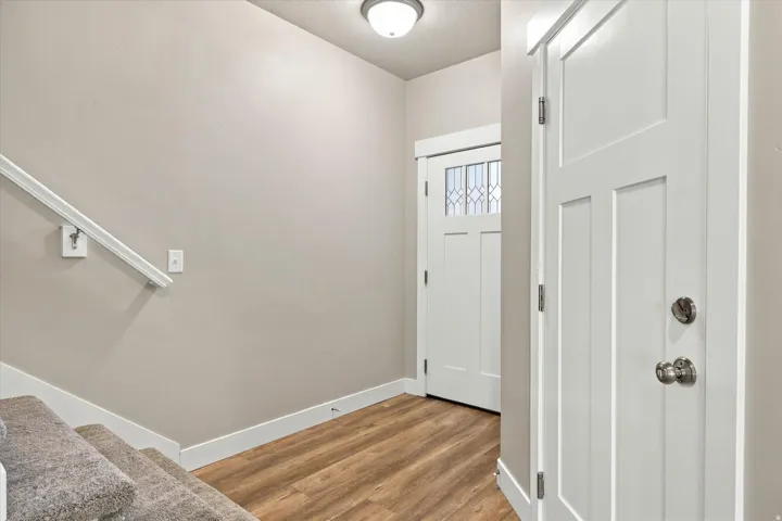 Wood-finish flooring, white trim, recessed lighting, white panel doors, and a staircase with carpeted treads