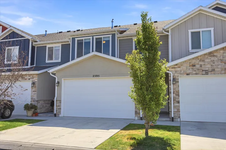 Two-story townhome with a stucco and siding exterior, integrated two-car garage, and concrete driveway
