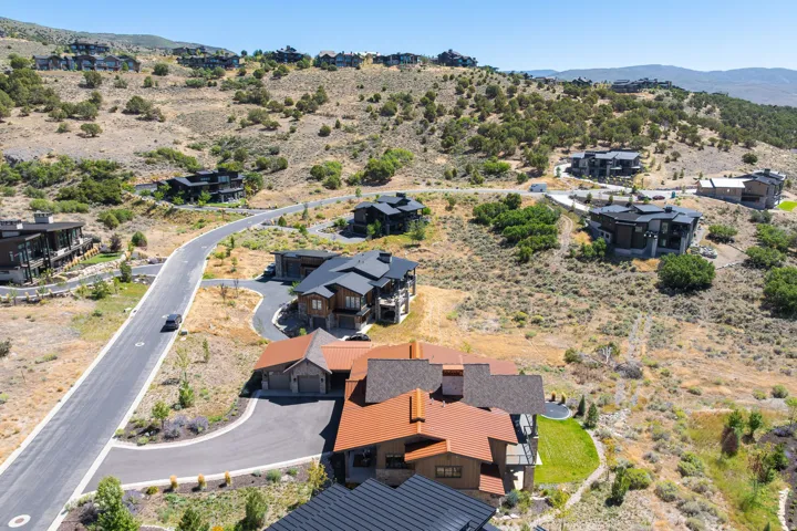 Hillside residential community with varied architectural styles, paved roads, and natural landscaping