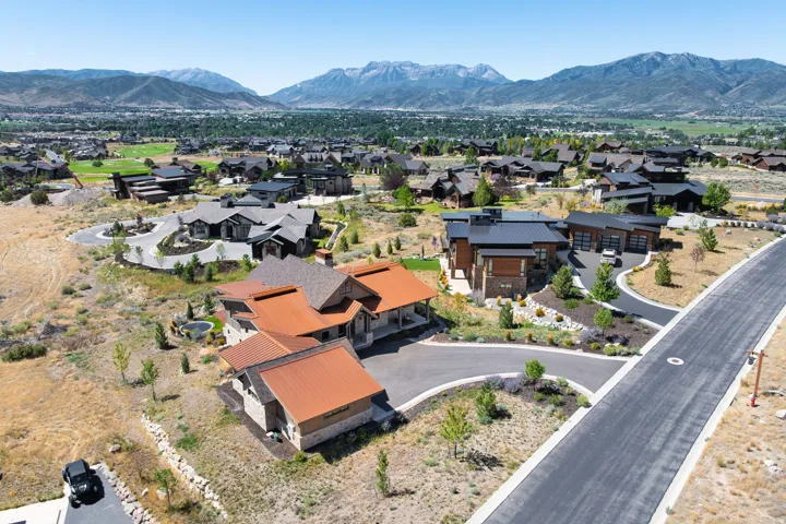 Expansive mountain backdrop with a residential community featuring multiple properties with varied architectural styles