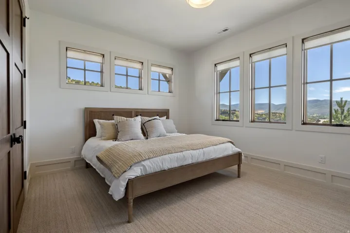 Light-toned carpeting, wood-paneled door, and multiple windows with grid patterns