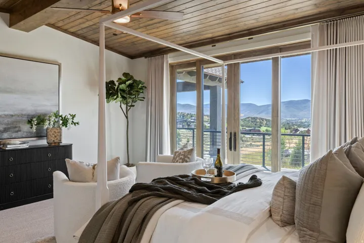 Vaulted wood-paneled ceiling with exposed beams, sliding glass doors, built-in ceiling fan, and carpet flooring