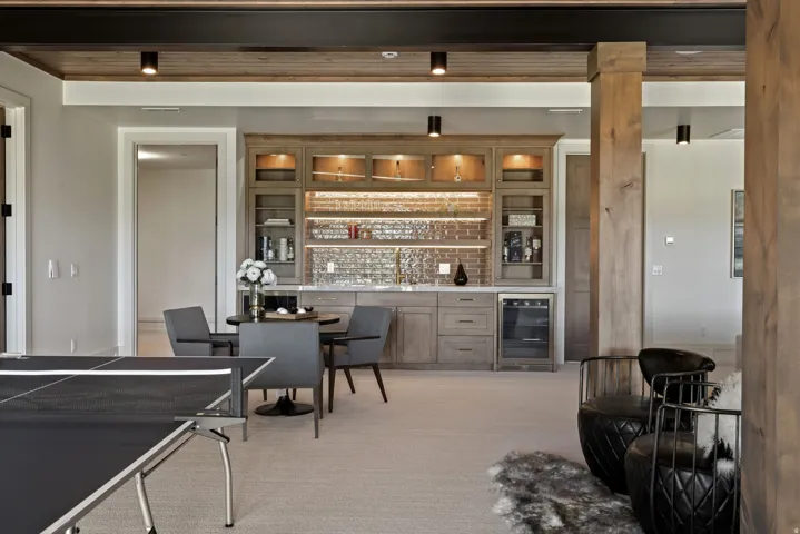 Built-in wet bar with wood-finish cabinetry, quartz countertop, and brick-patterned tile backsplash