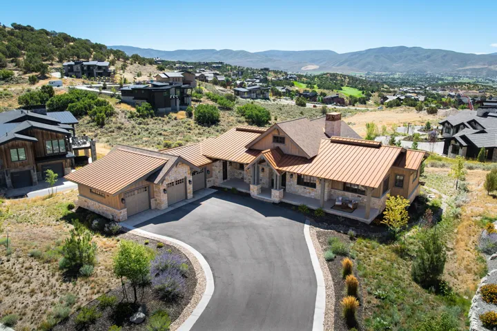 Stone and wood-clad exterior with a multi-gabled copper roof