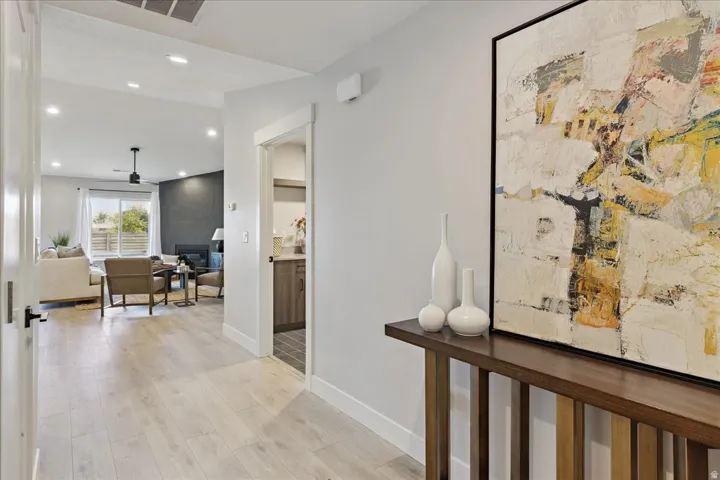 Wood-finish flooring throughout, recessed ceiling lighting, and a modern ceiling fan