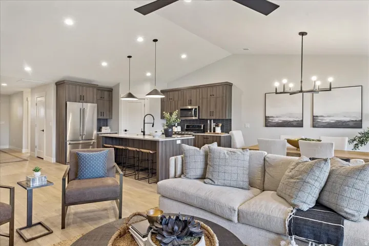 Open concept living area with vaulted ceilings, recessed lighting, wood-finish flooring, and a ceiling fan