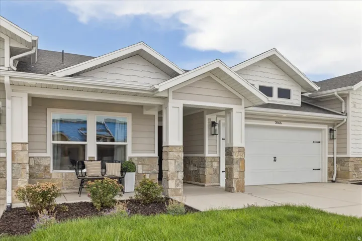 Stone veneer accents complement the light-toned siding