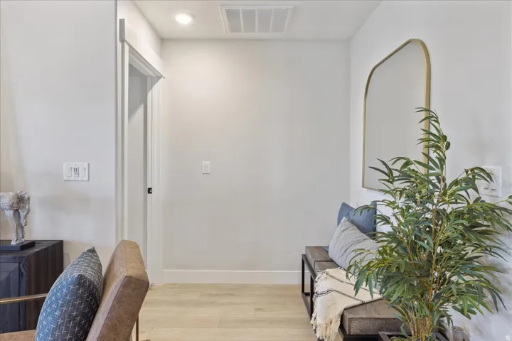 Recessed lighting illuminates wood-finish flooring