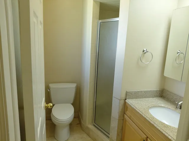 Bathroom featuring a shower with a frosted glass enclosure, a vanity with a light-colored countertop, and a built-in sink