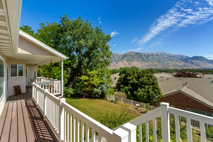 Outdoor deck with composite flooring and white railings, offering an expansive mountain backdrop