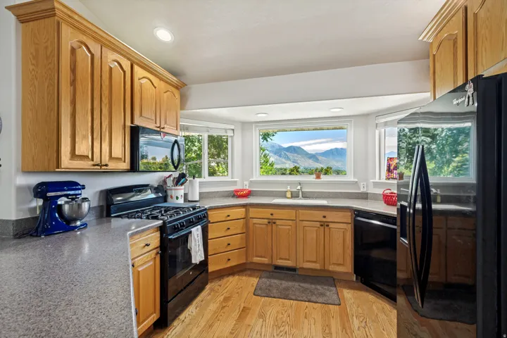 Kitchen featuring wood cabinetry, stone-finish countertops, and integrated appliances