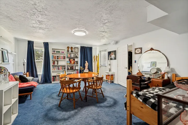 Recessed lighting, built-in shelving, and a wood-finish dining table