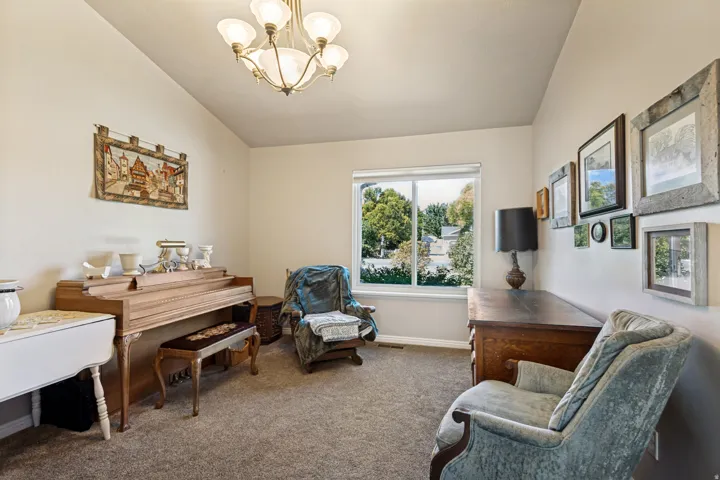 Recessed window with natural light, textured carpeting, and a decorative ceiling fixture