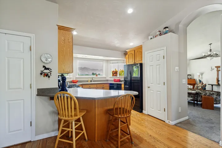 Kitchen featuring wood-finish flooring, light wood cabinetry, recessed lighting, and a kitchen island with a breakfast bar