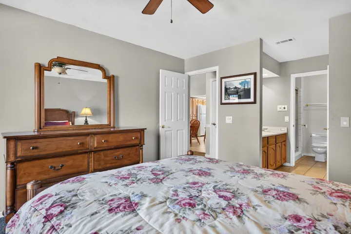 Ceiling fan, neutral wall tones, white interior doors, vanity with wood-finish cabinetry, ceramic tile flooring